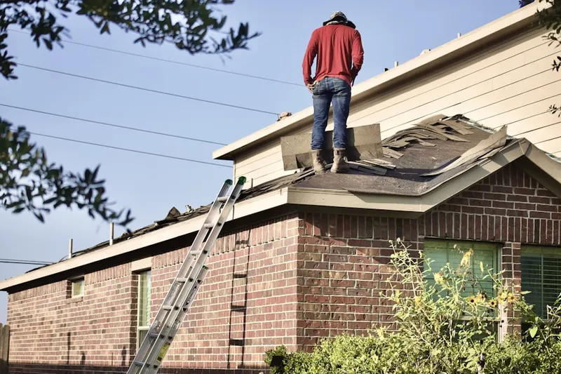 Professional roofer working on a residential roof in Poplar-Davie